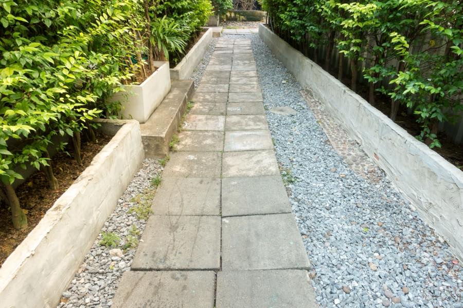 A flagstone path bordered by gravel and low planting